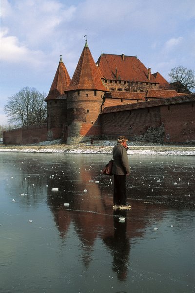 Bir kalenin önünde donmuş bir nehirde duran bir adamın yan profili, Nogat Nehri, Malbork Kalesi, Malbork, Pomorskie Eyaleti, Polonya by Benjamin Baud