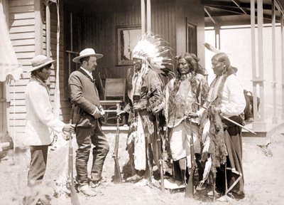Tören kostümü giymiş ve silahlı üç Cheyenne, tercüman eşliğinde bir Beyaz