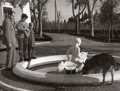 Gino Bartali, iki çocuğu ve bir köpeğiyle çeşmenin yanında by Unknown photographer