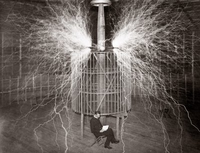 Nikola Tesla, Colorado Springs laboratuvarında “Büyüteç Vericisi” ile oturuyor by Unknown photographer