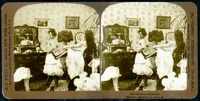 Stereoscopic card depicting a woman being laced into a corset, c.1900 (sepia photo) (see also 473244) by Vermont, USA H.C. White Company