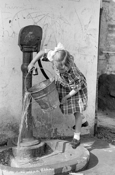 Tulumba çeşmesinde bir kova suyu boşaltan küçük kız, 9 Mayıs 1939 (b/w fotoğraf) by Vincenzo Balocchi
