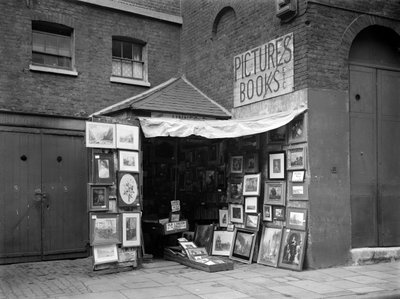 İkinci el kitap ve resim dükkanının önünde sergilenen çerçeveli resimler, Londra, 1933. by WA Clark