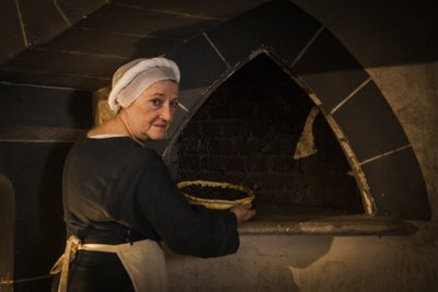 Tarihi canlandırma: Kale mutfağının fırınına pasta koyan hizmetçi by John Ward Dunsmore