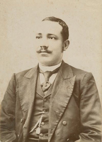 Koyu renk takım elbise giyen ve yeleğinde cep saati olan bir adamın fotoğrafı, 1886-1900. by W. M. Hubbard