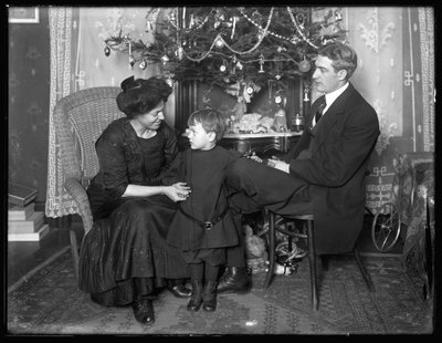 Dan Seymour ve ailesi resmi olmayan bir pozda, bir Noel ağacının altında oturuyorlar, Noel 1912 by William Davis Hassler