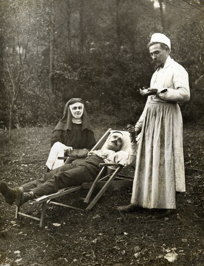Bir hemşire rahibenin yardımıyla yaralı bir adamın nabzını tutan doktor, yaklaşık 1900 (s/b fotoğraf) by . .