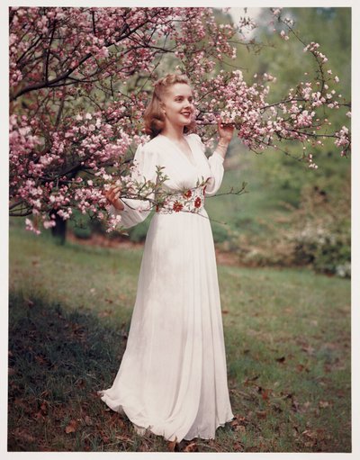 Çiçeğin yakınında bir elbise modelleyen kadın, 1940