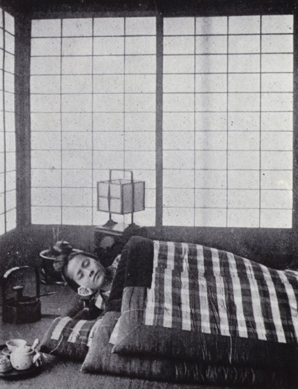 Tahta bir yastıkla pamuklu yorganlar arasında uyuyan kız (s/b fotoğraf) by American Photographer (after)