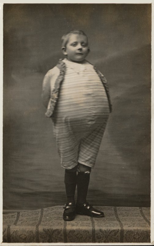 Okul çocuğu, çok büyük bir mideye sahip olacak şekilde giyinmiş (s/b fotoğraf) by English Photographer