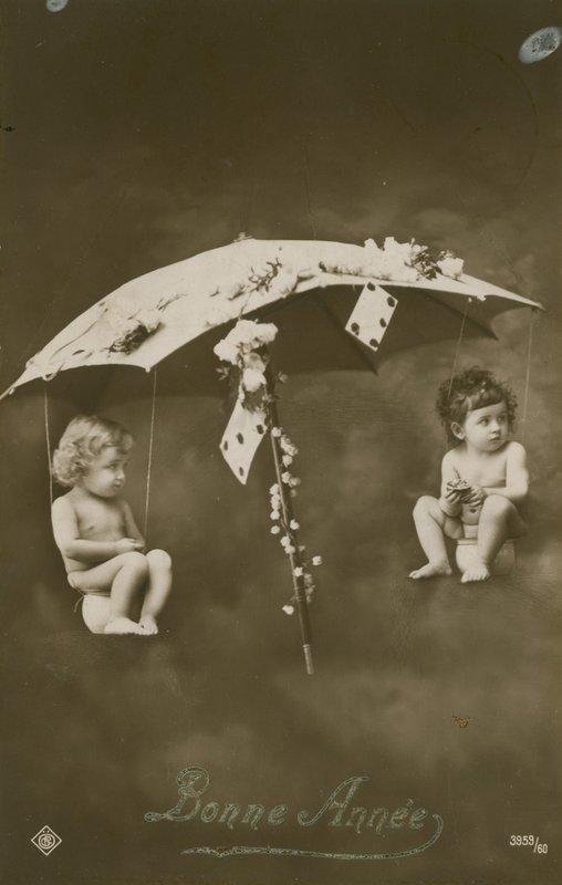 1913 yılında gönderilen bir şemsiyeden sarkan iki bebek ile Mutlu Yıllar kartı by French Photographer