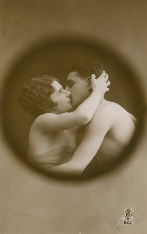 Bir gözetleme deliğinden görüldüğü gibi öpüşen genç adam ve kadın. 1913 yılında gönderilen kartpostal. by French Photographer