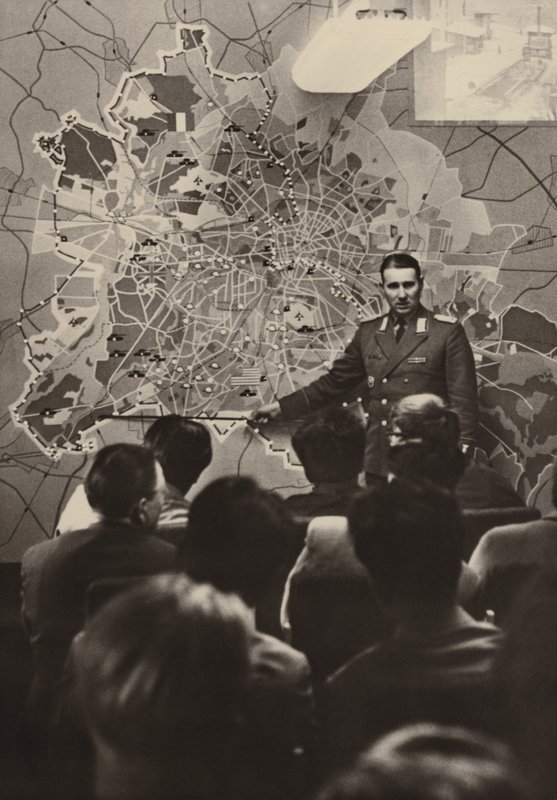 Ulusal Halk Silahlı Kuvvetlerinden bir subay, Brandenburg Kapısı'ndaki yabancı ziyaretçilere antifaşist koruma duvarının gerekliliğini açıklıyor .... (s/b fotoğraf) by Photographer German